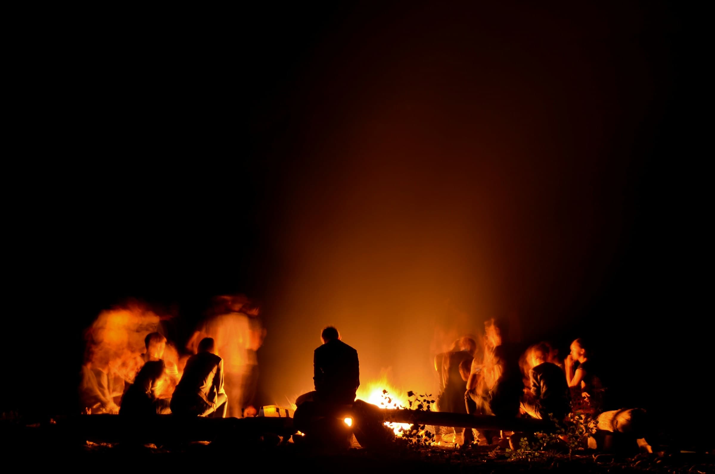Des gens autour d'un feu, la nuit